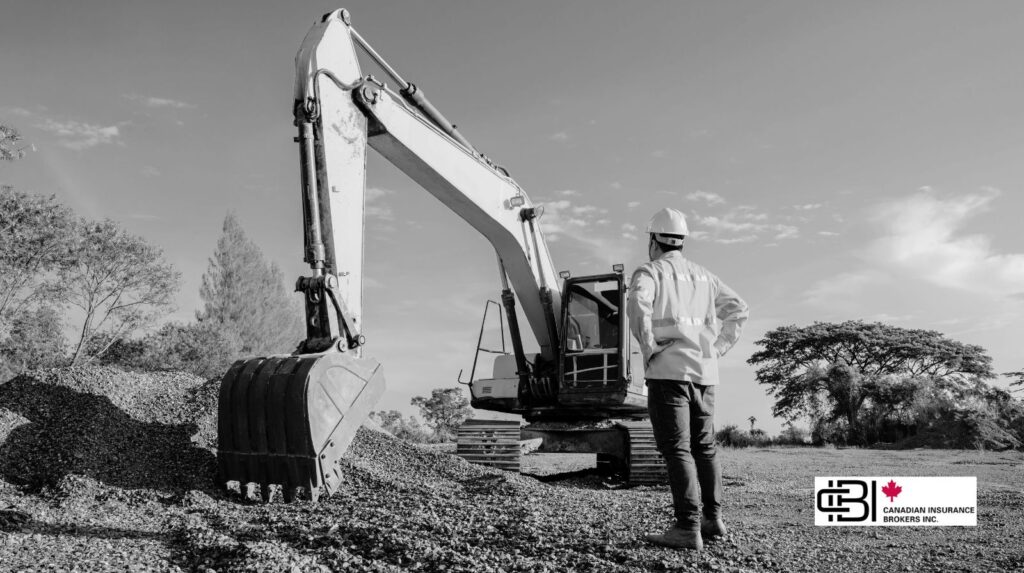 Construction worker beside an excavator at a job site, representing excavation insurance Ontario.