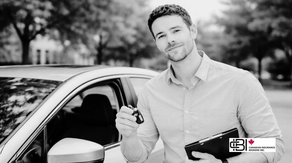 James Inwood standing beside a car holding keys and a clipboard while assisting clients with insurance coverage.