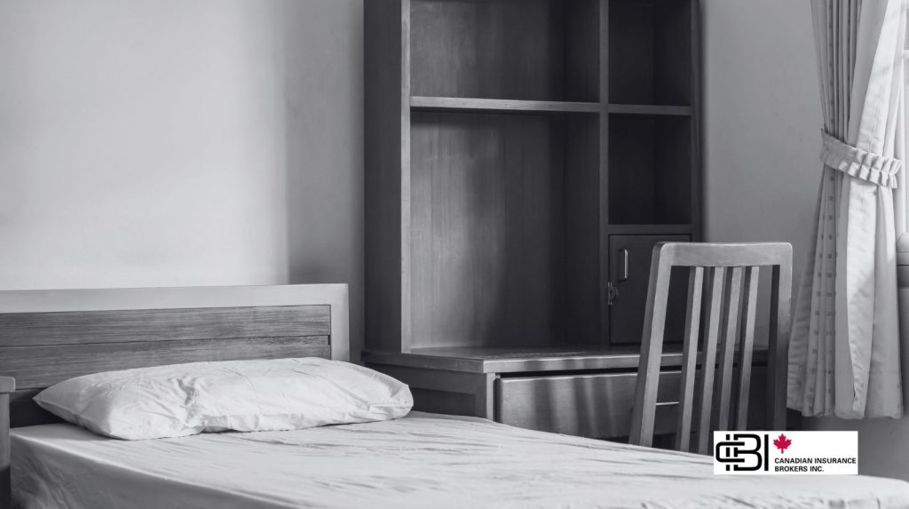 Minimal student bedroom with single bed, desk, and wardrobe, illustrating student housing insurance coverage for basic living spaces.