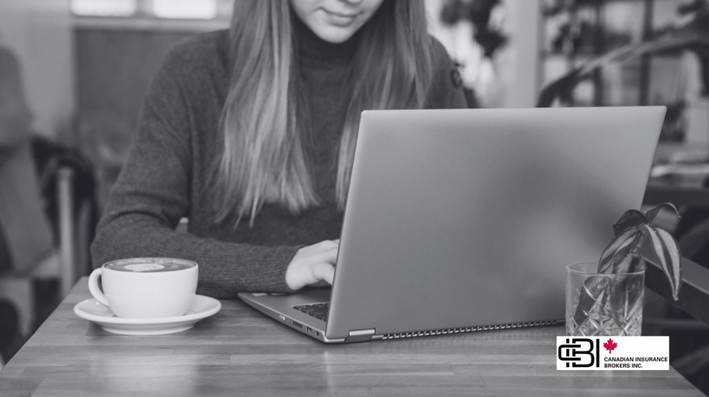 Freelancer working on laptop at café table, highlighting the need for freelancers insurance protection