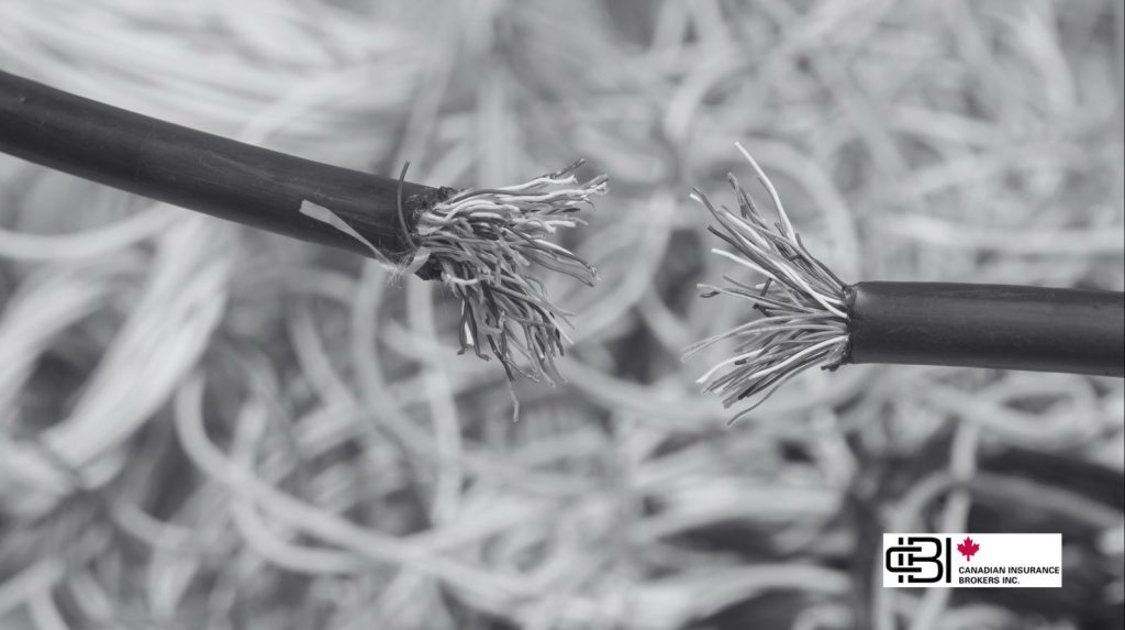 Close-up of damaged electrical wires with exposed strands, illustrating risks covered by equipment breakdown insurance such as electrical failure and arcing.