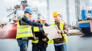 Engineers reviewing plans on a job site, wearing safety helmets and high-visibility vests, for an engineering project in Ontario.