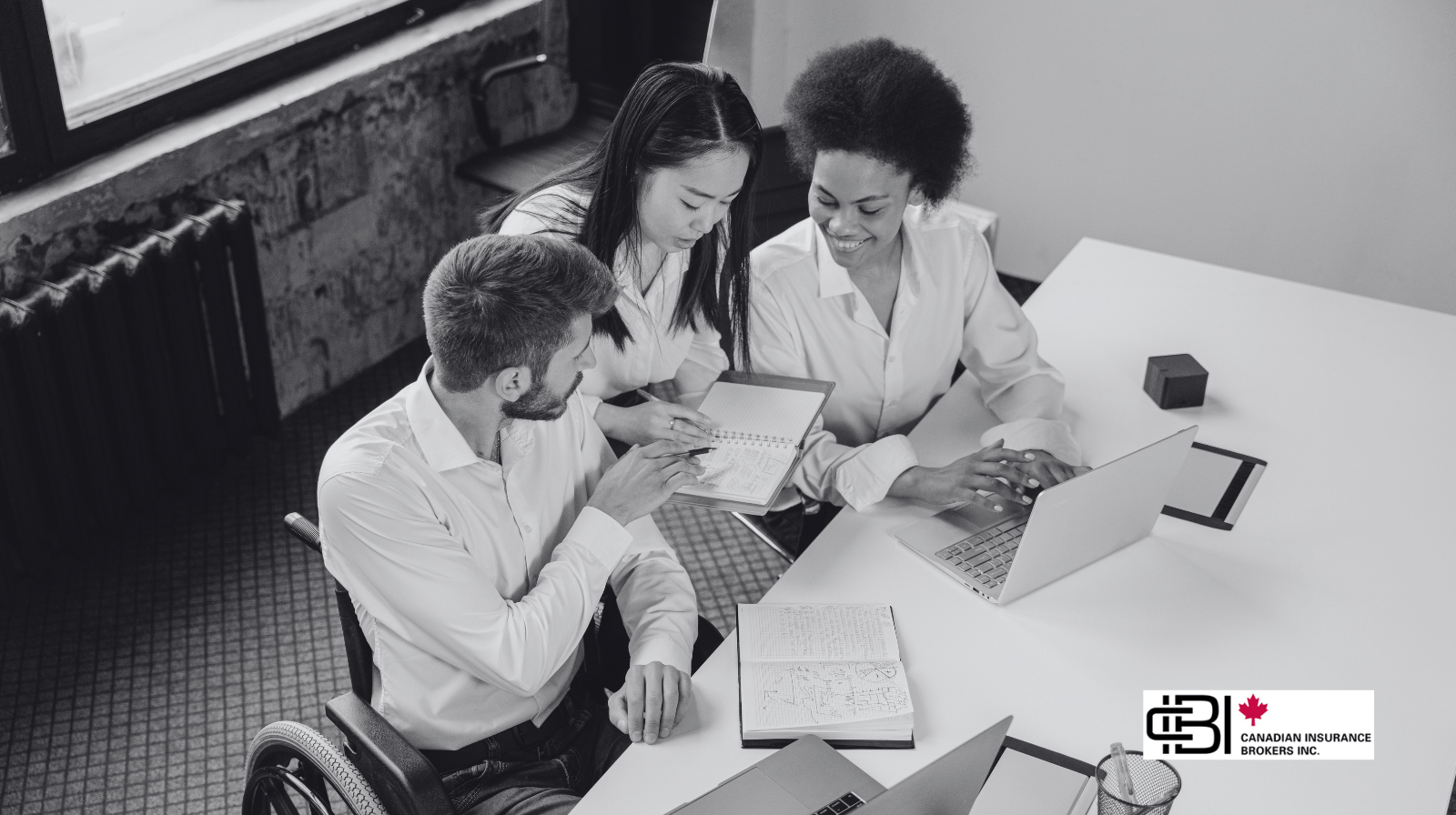 Insurance brokerage team reviewing insurance exclusions and policy details together at a laptop.